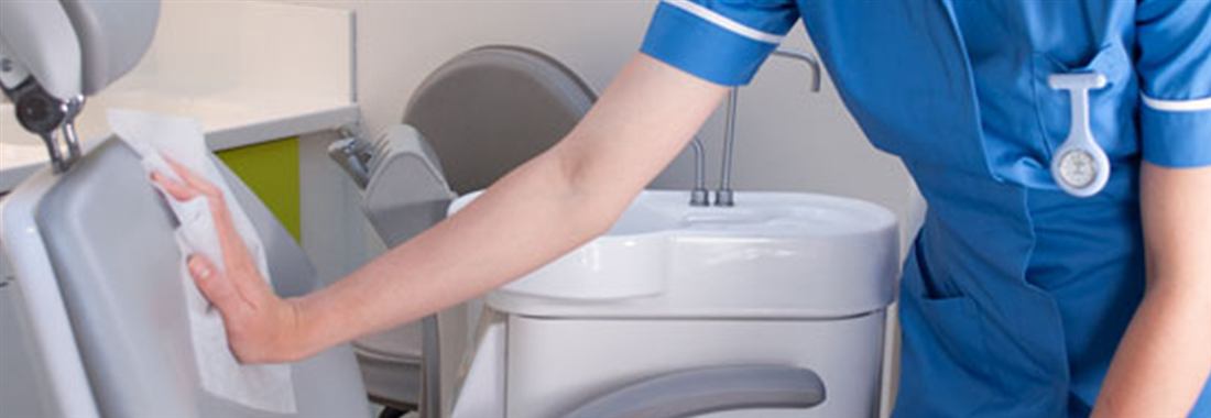 Dental chair being wiped down between patients