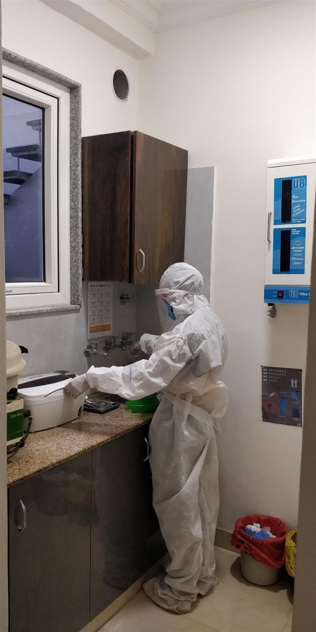 Dental Arch staff member in protective gear cleaning instruments in the sterilisation area